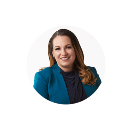 Woman with long brown hair smiles and poses for a headshot.
