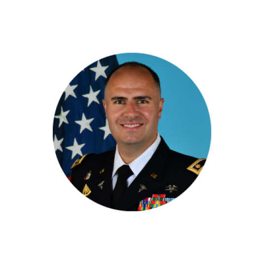 Smiling man named Michael Baddley wearing military uniform with American flag in the background.