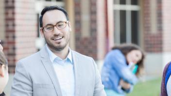 Principal man in schoolyard with middle school aged students.