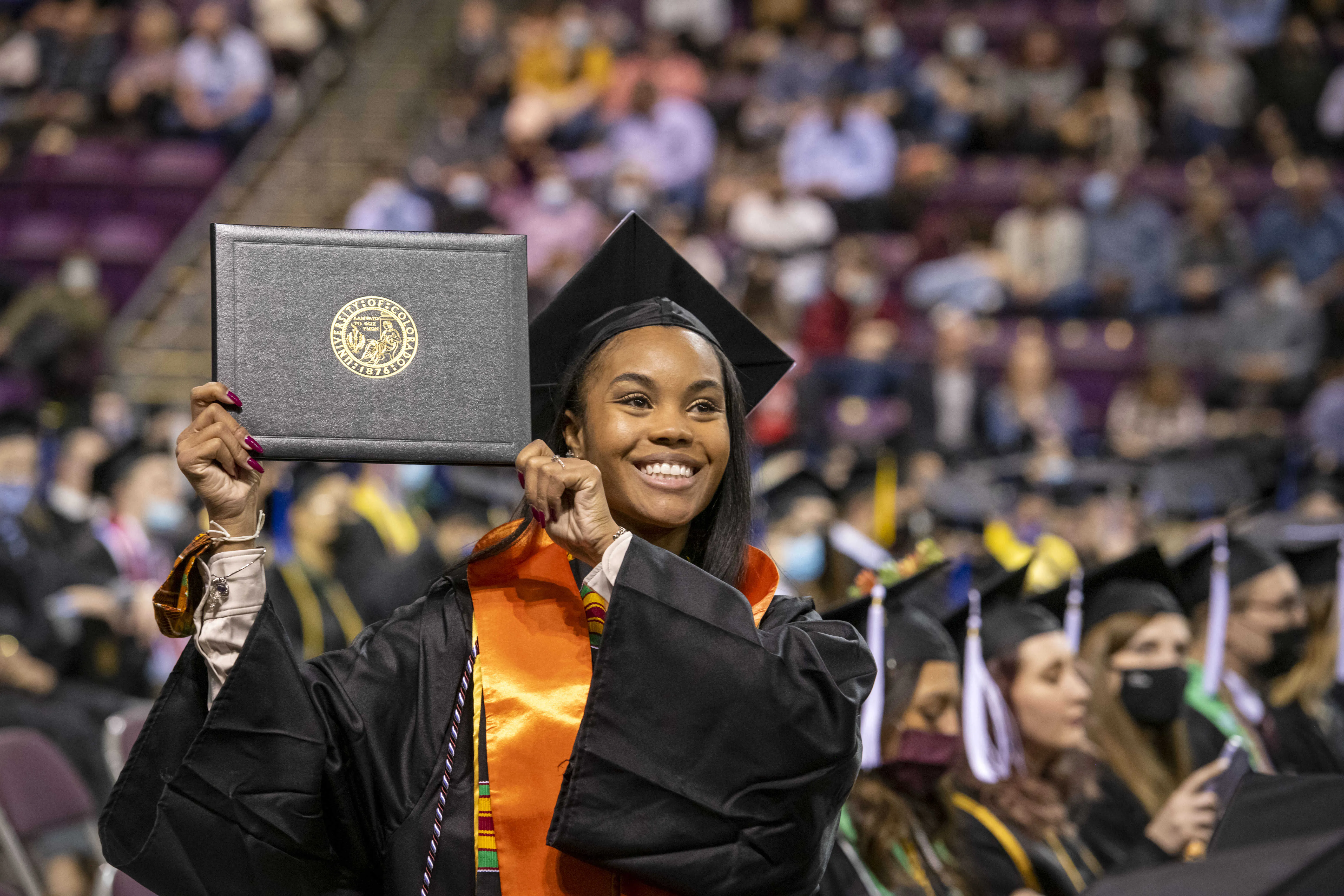 Graduating student at the commencement ceremony, holding her diploma 
